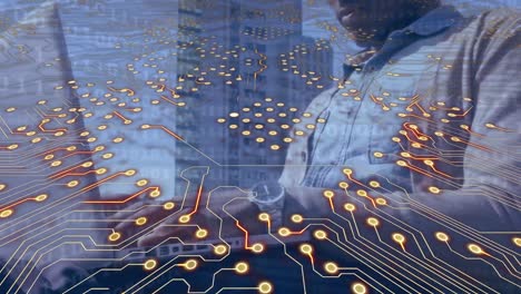 animación de un circuito integrado sobre las manos de un hombre afroamericano usando una computadora portátil