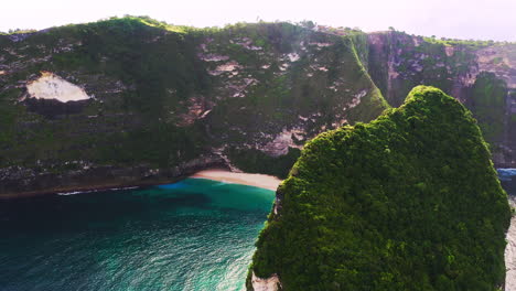 Kelingking-beach-with-blue-water-below-steep-coastal-cliffs,-Indonesia