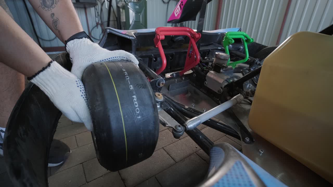 el mecánico del servicio de carreras de go kart cambia las ruedas