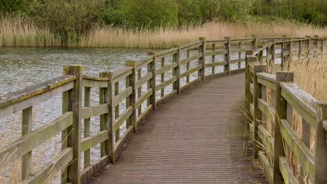 wide-shot-of-a-wooden-broad-walk-over-water-at-Waters'-Edge-Country-Park