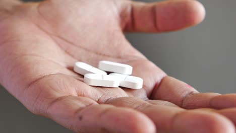 close up of man hand holding pills with copy space