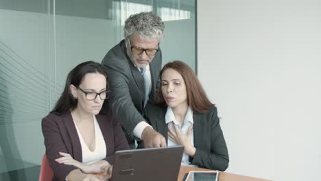 caucasian female managers showing project on laptop to ceo