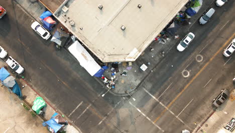aerial view of a street corner with a homeless encampment and makeshift shelters