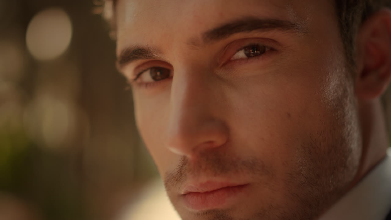 hombre caliente posando en el jardín. persona masculina romántica mirando fijamente a la lente al aire libre