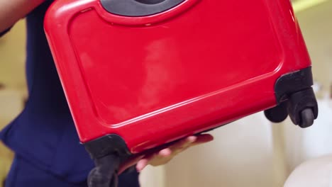 cabin crew lift luggage bag in airplane