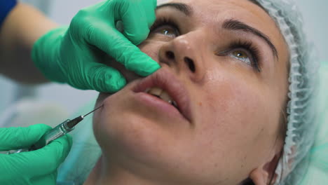 una mujer se somete a un procedimiento de inyección de relleno facial en la clínica