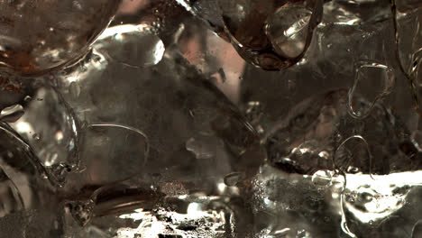 pouring soda on ice cubes extreme close-up