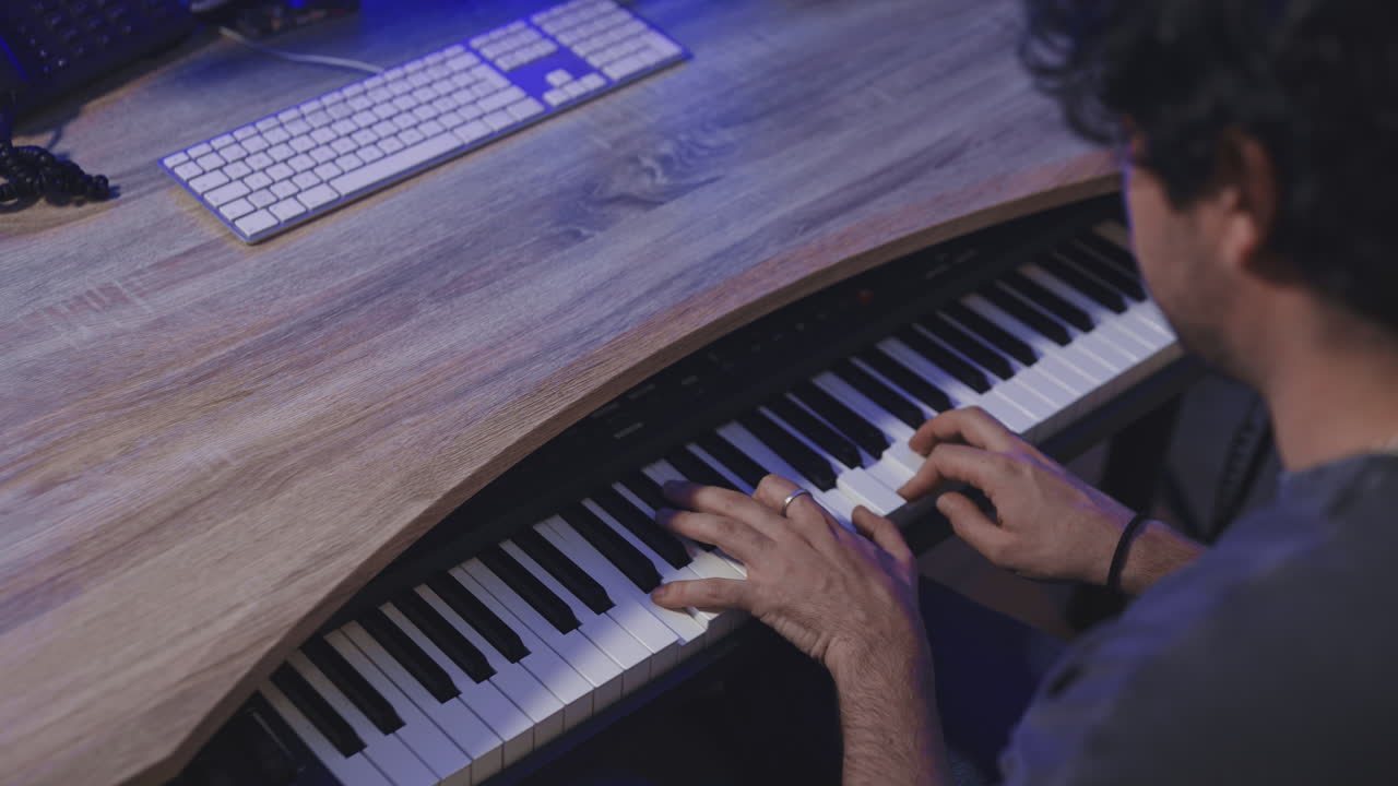 músico caucásico tocando el piano en su estudio de casa