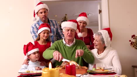 Familia-De-Tres-Generaciones-Cenando-Juntos-De-Navidad