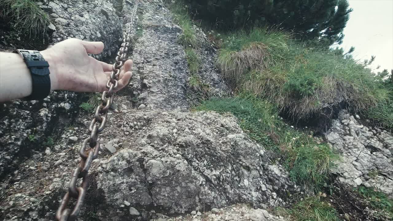 pov escalando un acantilado rocoso empinado en una montaña