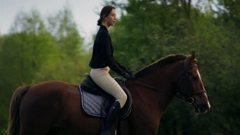 woman horseback riding in a field