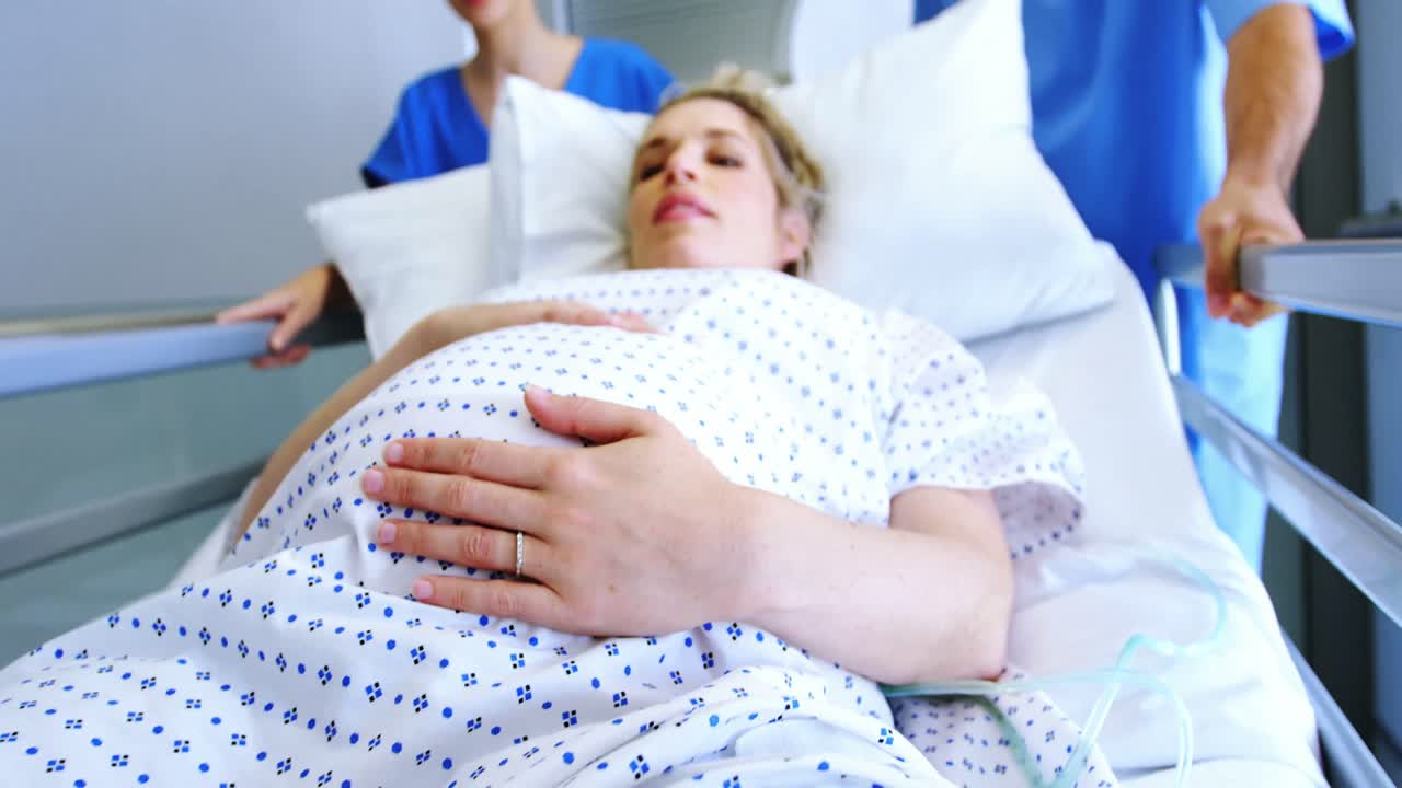 equipo de médicos que llevan a la mujer embarazada al quirófano