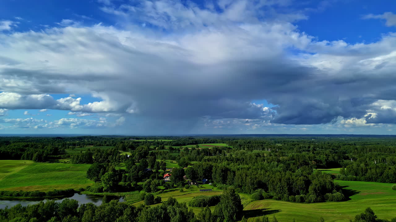 Bevægeligt luftfoto af tætte skyer over grønne landskaber