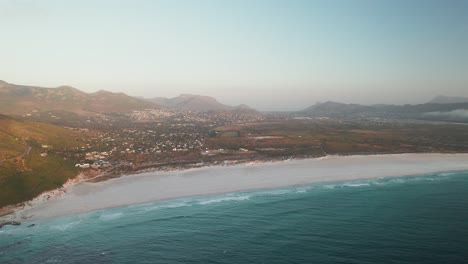 panoramic view of noordhoek coastal suburb and chapman's peak drive in cape town, south africa - drone shot
