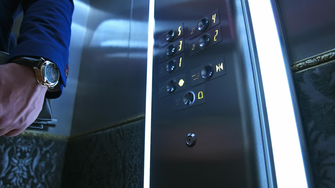 Man presses electronic button in lift. Man's hand touches elevator buttons in a hotel. Businessman in modern elevator. Close-up.