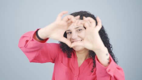 Young-woman-making-heart-sign-at-camera.