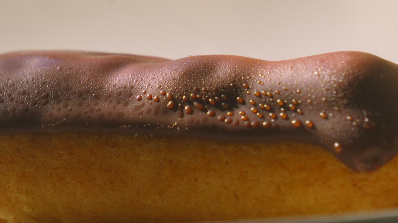 Close Up Very Slow Pan Revealing Eclair Topped with Chocolate and Puff Pastry Filled with Whipped Cream. Traditonal French Dessert Ready to Eat and Enjoy. Food Photography.