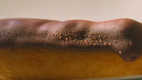 close up very slow pan revealing eclair topped with chocolate and puff pastry filled with whipped cream. traditonal french dessert ready to eat and enjoy. food photography.