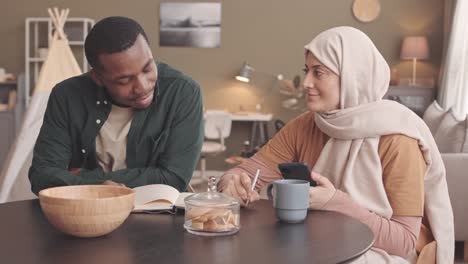 interracial muslim couple counting bills together at home