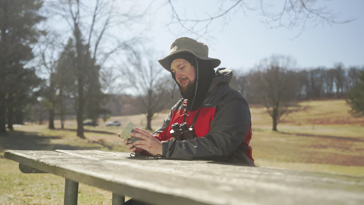 자연 속에서 사진을 찍고 쌍안경으로 바라보는 남자