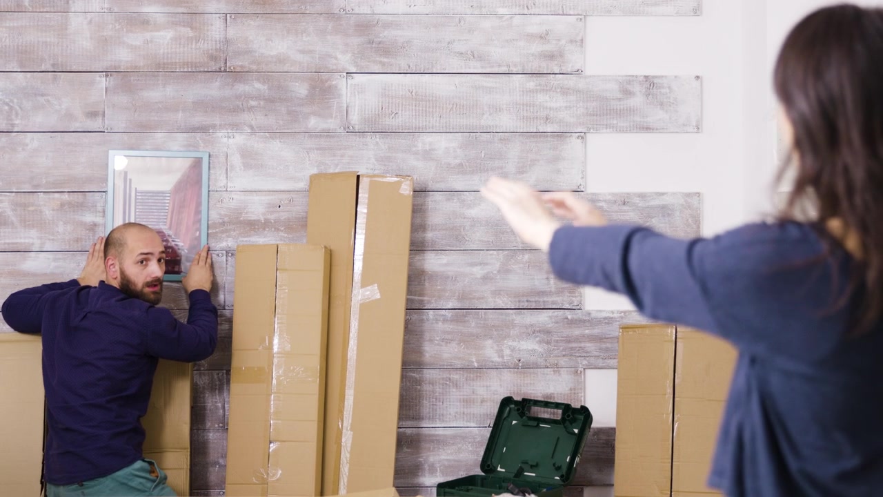 Stel Hangt Fotolijst Op aan Muur in Hun Nieuwe Huis