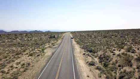 a lonely car is parking on a straight highway in the desert