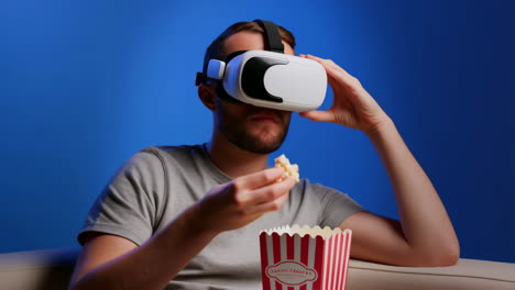 man wearing vr headset and eating popcorn