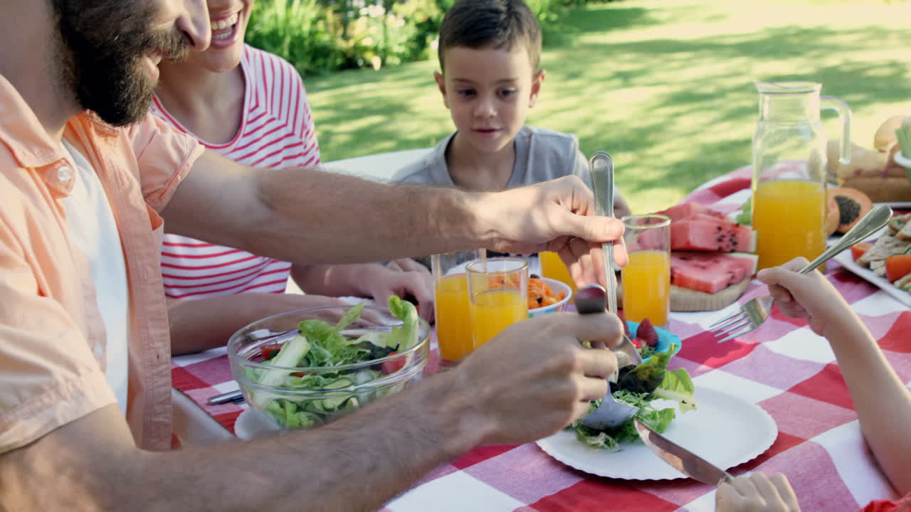 familia feliz está comiendo juntos en el jardín