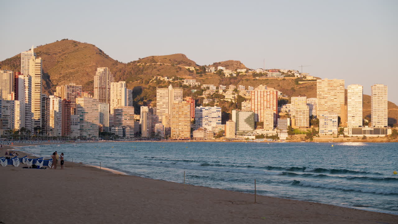 Benidorm, Spain - May 25, 2025: Golden hour Benidorm skyline over calm Levante Beach