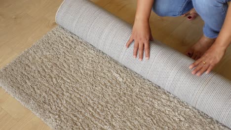 woman rolling up a carpet