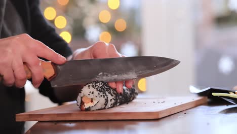 making sushi at home kitchen. woman hands rolling homemade sushi.