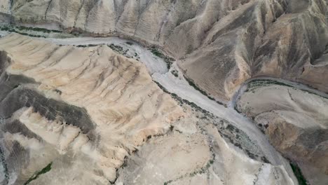 aerial-view-of-dry-river-path-in-Judea-desert-hills,-Israel