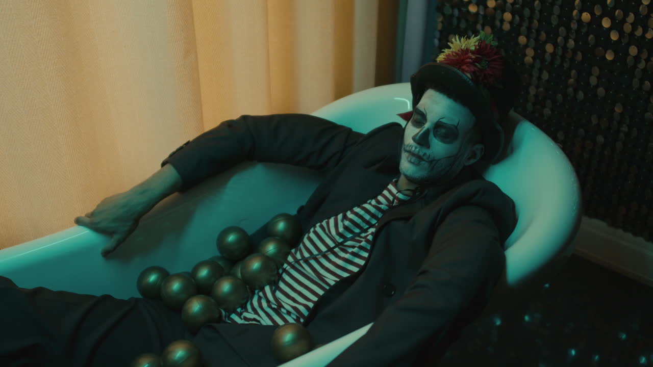 에서 황금 공을 들고 욕조에서 잠을 자는 젊은 남자의 면.