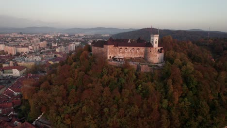 Toma-Aérea-Giratoria-Del-Castillo-De-Liubliana-Al-Atardecer