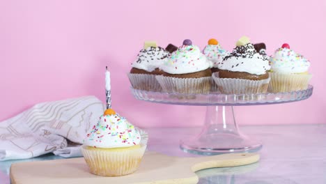 blowing birthday candle on sweet cup cake served on the table for party