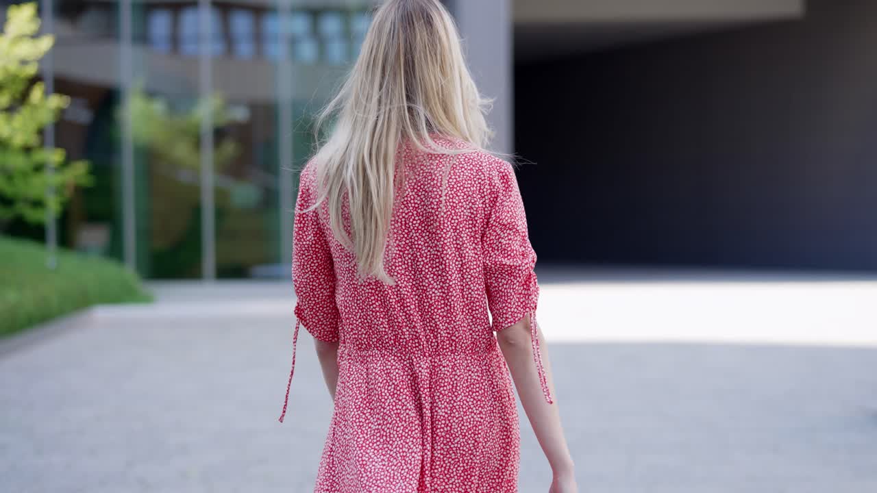 은 드레스 를 입은 여자 가 야외 에서 고 있다