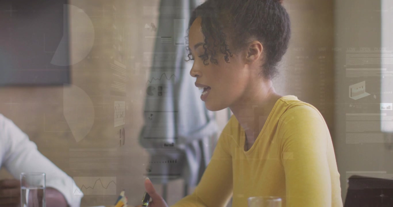 Woman referencing and reacting to business colleague prompt while animated charts overlaying papers