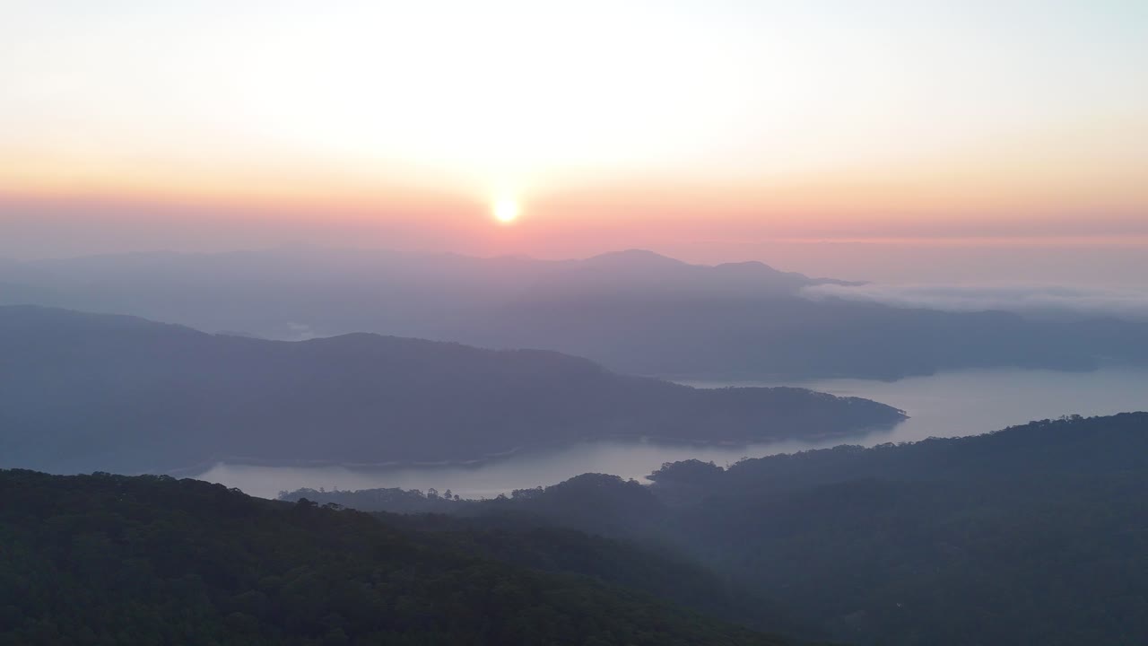 sunrise over the lake in the valley and clouds drifting over the mountains