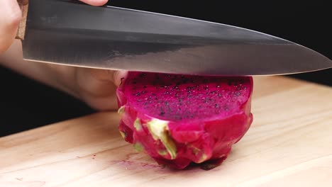 slicing a dragon fruit on a cutting board