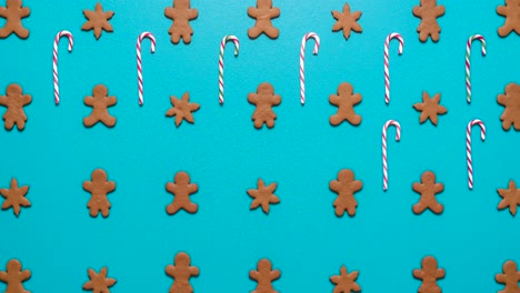 gingerbread cookies and candy canes flat lay on a blue background.