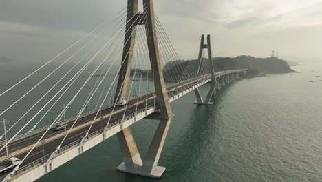 aerial view of bridge to busan, south korea from geoje island early in the morning as traffic passes by