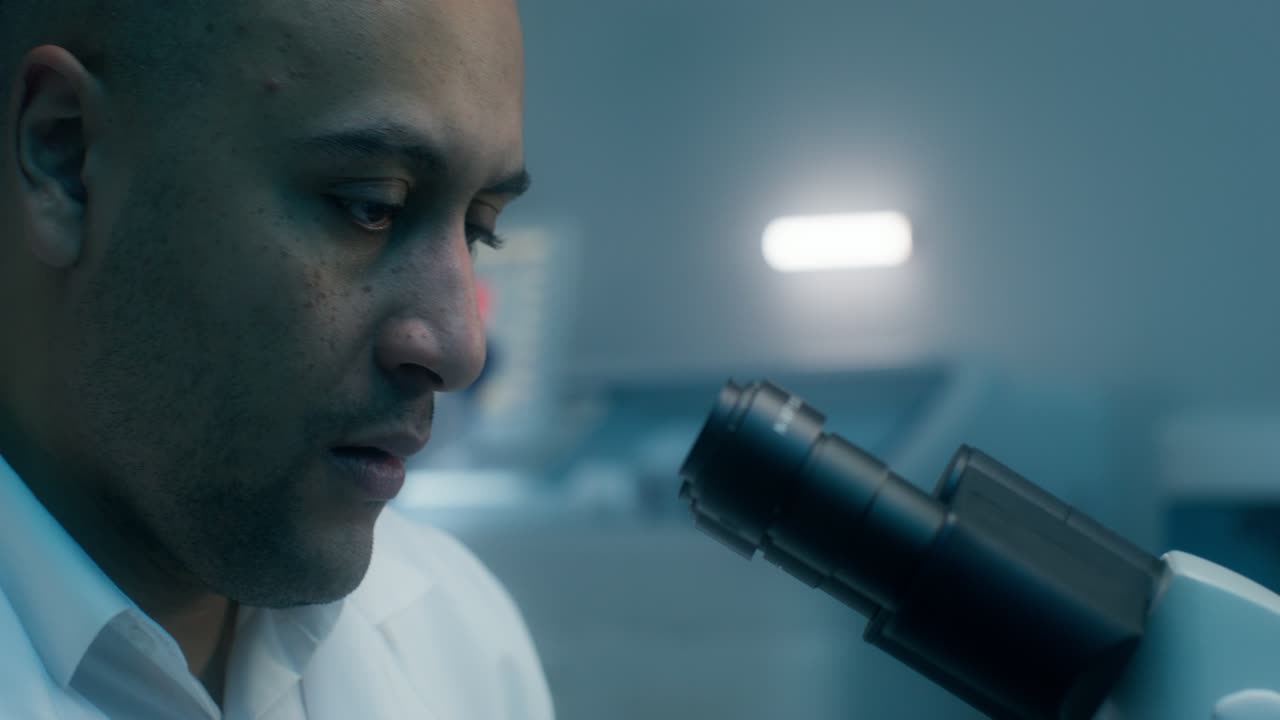 científico examinando la muestra bajo el microscopio