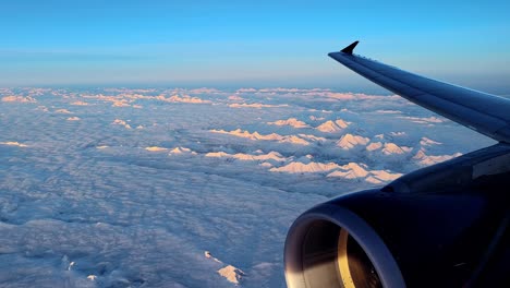 Montañas-Rocosas-Cubiertas-De-Nieve-Vistas-Desde-La-Ventana-Del-Avión-Al-Atardecer