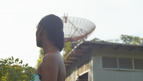 a young girl looks up at an abandoned radar tracking station on the caribbean island of trinidad