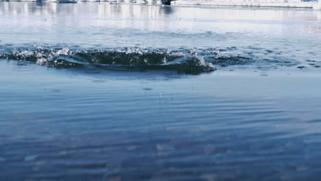 Steinhüpfen-Auf-Dem-Wasser-Einer-Gletscherlagune-In-Island