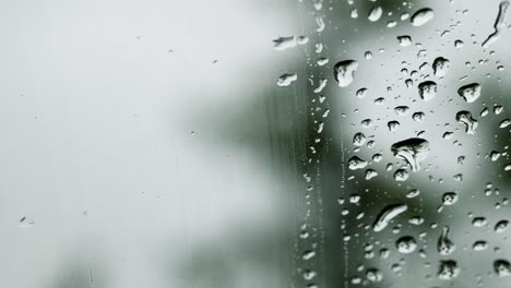 the car's wiper cleans the glass and creates movements of water shapes.macro water drops flowing on a window glass.