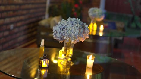 close-up of elegant table centerpiece with hydrangea bouquet and candlelight, romantic wedding evening ambiance