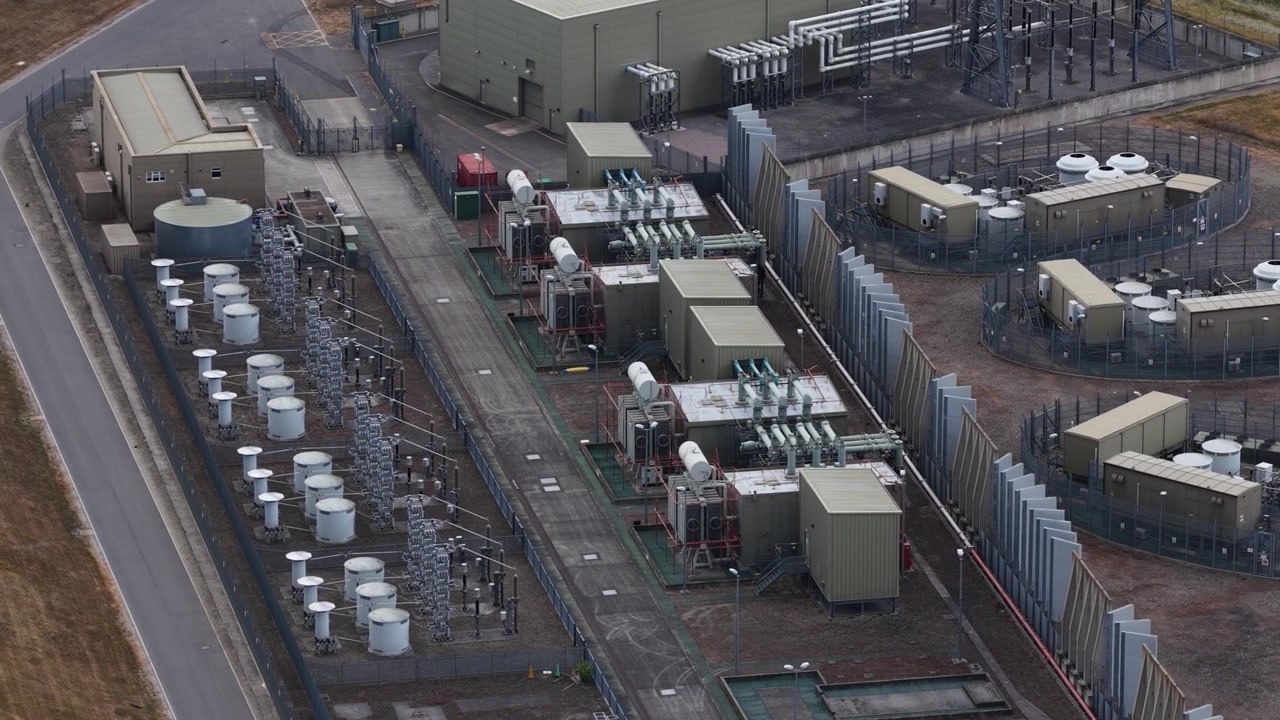 High angle view showcasing a modern electrical power plant with its complex grid of transformers, pylons, and high voltage equipment for energy generation and distribution