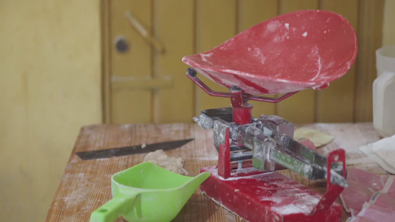 토르라 또는 플래트브레드 를 위한 반죽 을 준비 하기 위해 베이커리 에서 토르러 프레스 를 운영 하는 사람