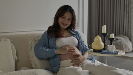 asiatic young pregnant woman touching her big belly waiting for a newborn baby